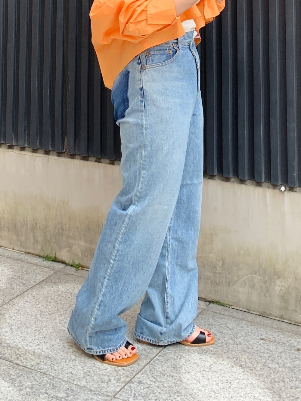 オレンジ系のシャツ/ブラウス、ホワイト系のキャミソール、ブルー系のデニムパンツを着用したレディースの春コーディネートの6枚目の写真