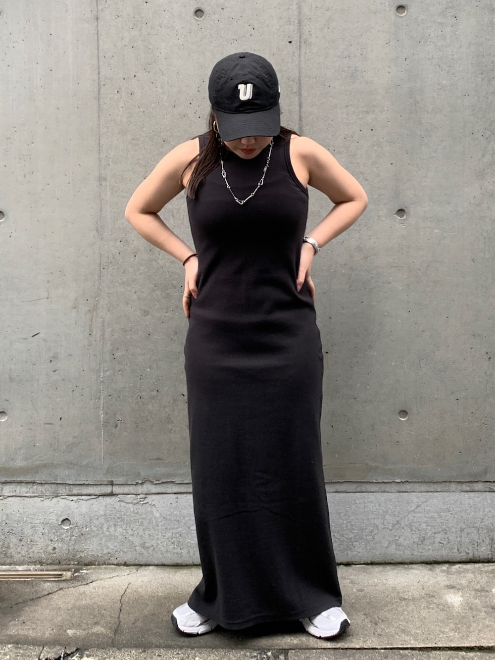 グレー系のベスト、ブラック系のワンピースを着用したレディースの春コーディネートの4枚目の写真