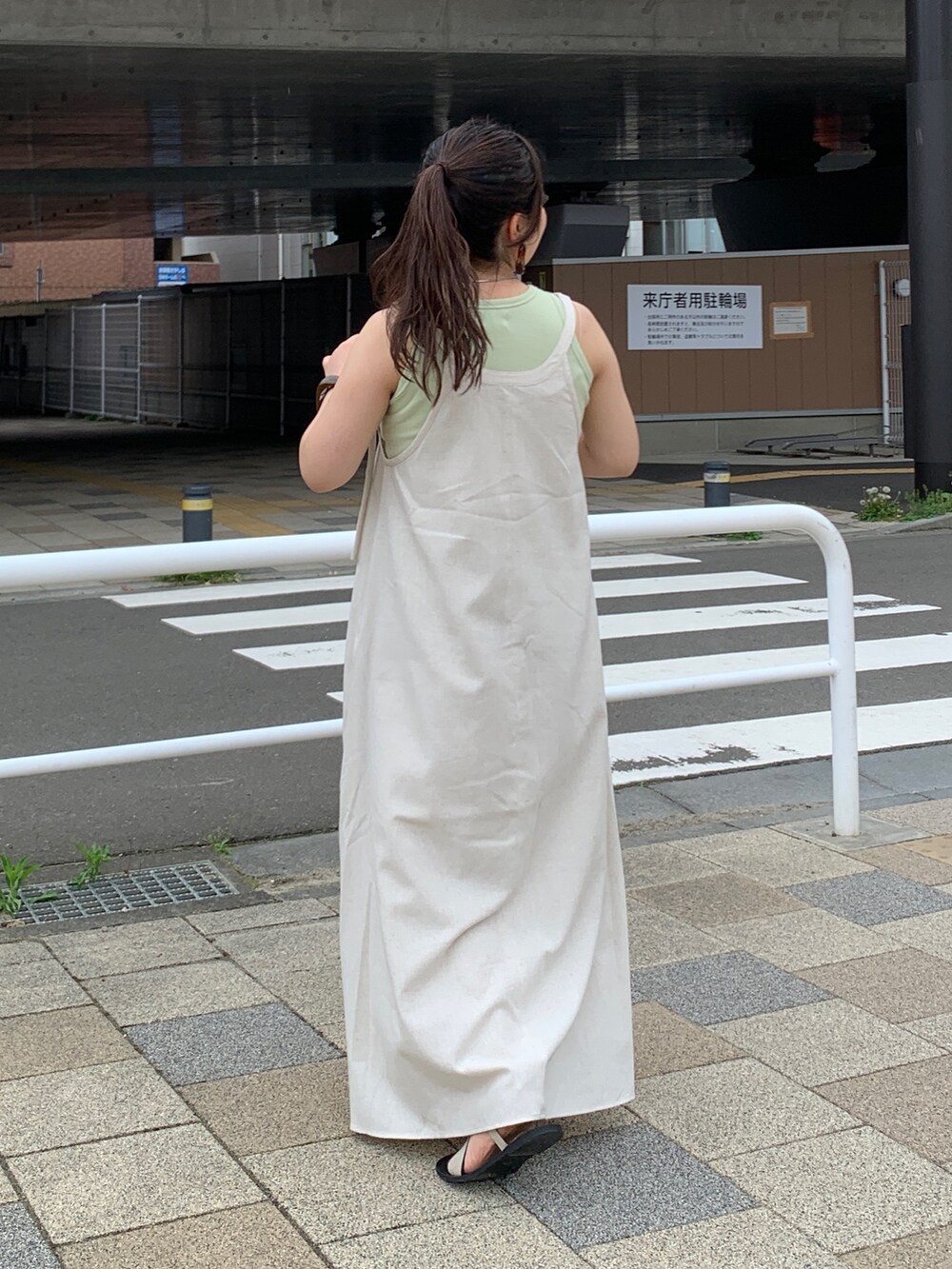 ホワイト系のワンピース、グリーン系のタンクトップを着用したレディースの春コーディネートの3枚目の写真
