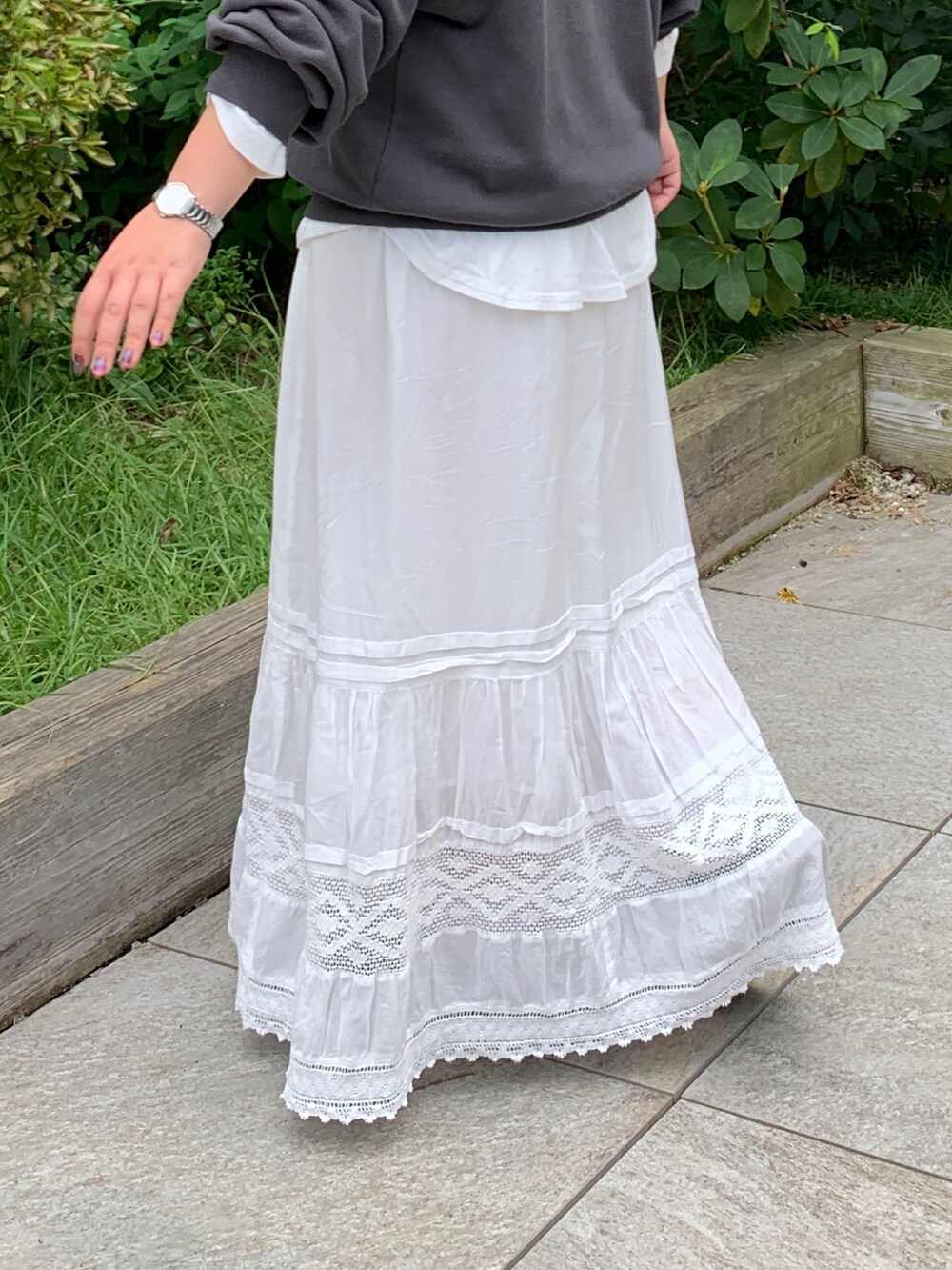 グレー系のスウェット、ホワイト系のTシャツ/カットソー、ホワイト系のスカートを着用したレディースの秋コーディネートの6枚目の写真