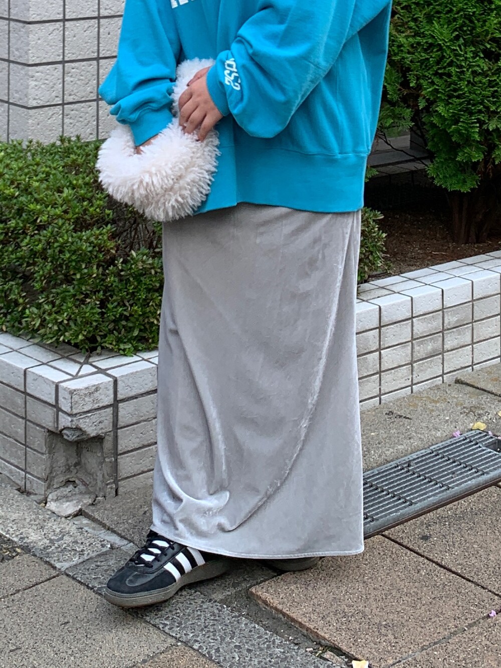 ブルー系のスウェット、ホワイト系のハンドバッグ、グレー系のスカートを着用したレディースの秋コーディネートの5枚目の写真