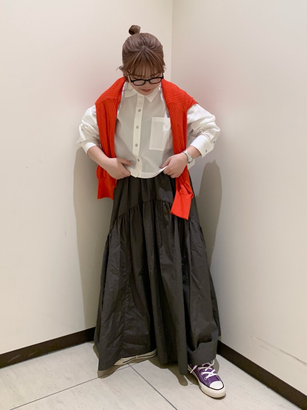 オレンジ系のカーディガン/ボレロ、ホワイト系のシャツ/ブラウス、グレー系のスカートを着用したレディースの春コーディネートの2枚目の写真