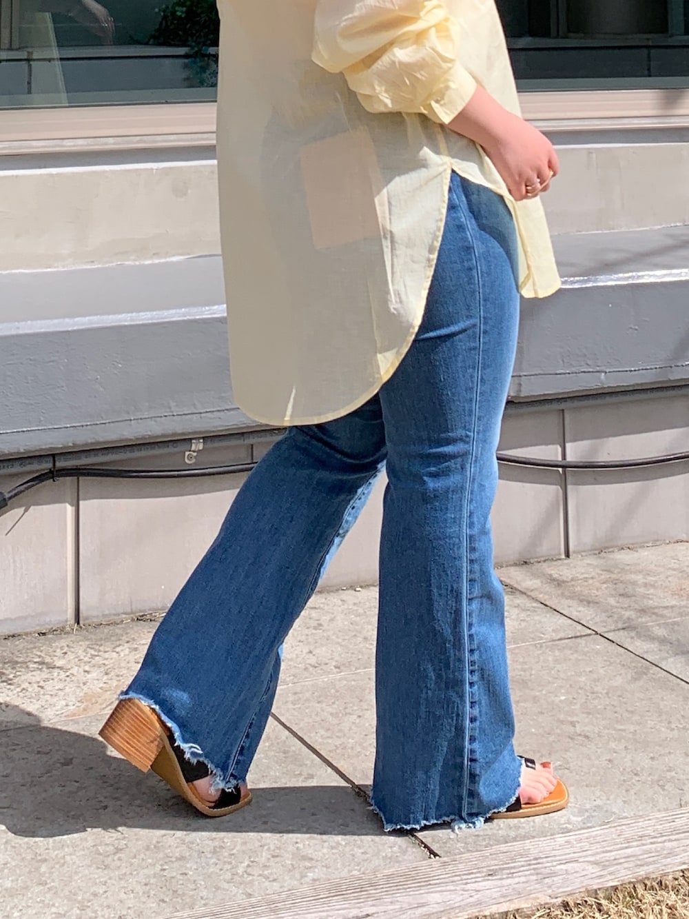 イエロー系のシャツ/ブラウス、ブルー系のデニムパンツ、ブラック系のサンダルを着用したレディースの春コーディネートの5枚目の写真