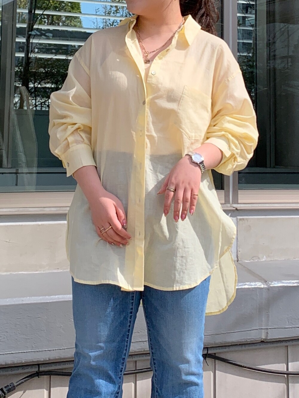 イエロー系のシャツ/ブラウス、ブルー系のデニムパンツ、ブラック系のサンダルを着用したレディースの春コーディネートの7枚目の写真