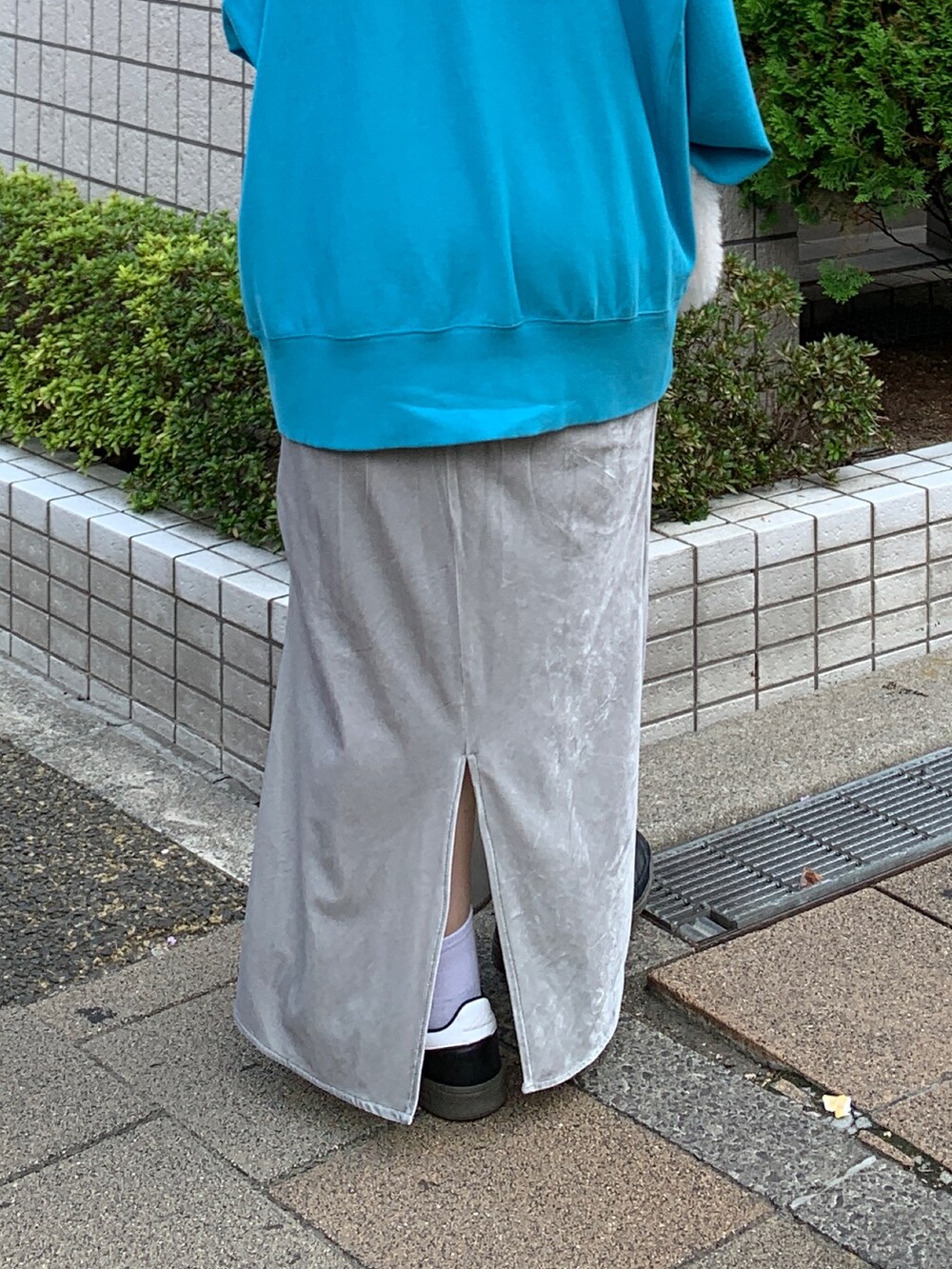 ブルー系のスウェット、ホワイト系のハンドバッグ、グレー系のスカートを着用したレディースの秋コーディネートの7枚目の写真