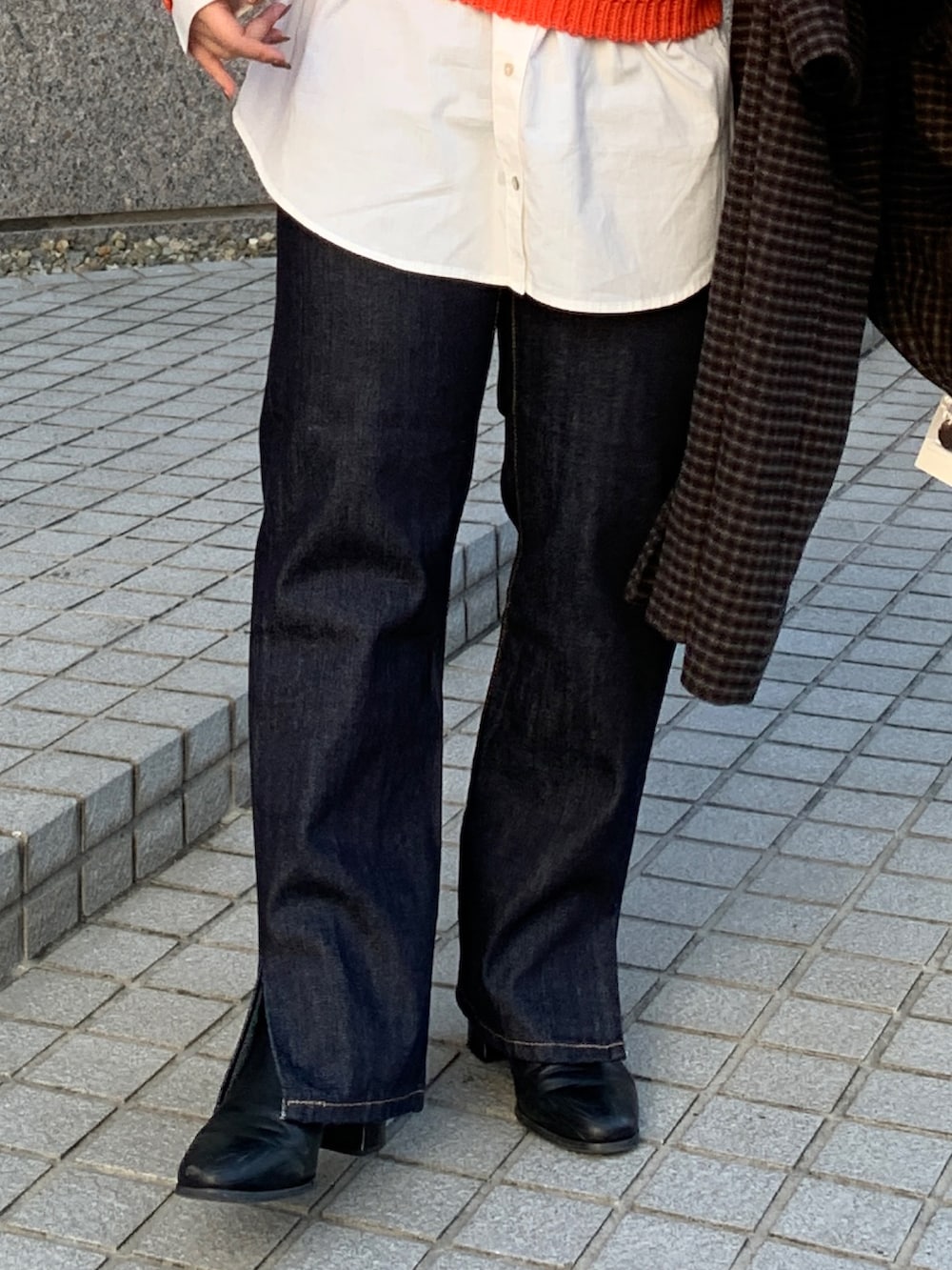 オレンジ系のニット/セーター、その他のチェスターコート、ブルー系のデニムパンツを着用したレディースの秋コーディネートの8枚目の写真