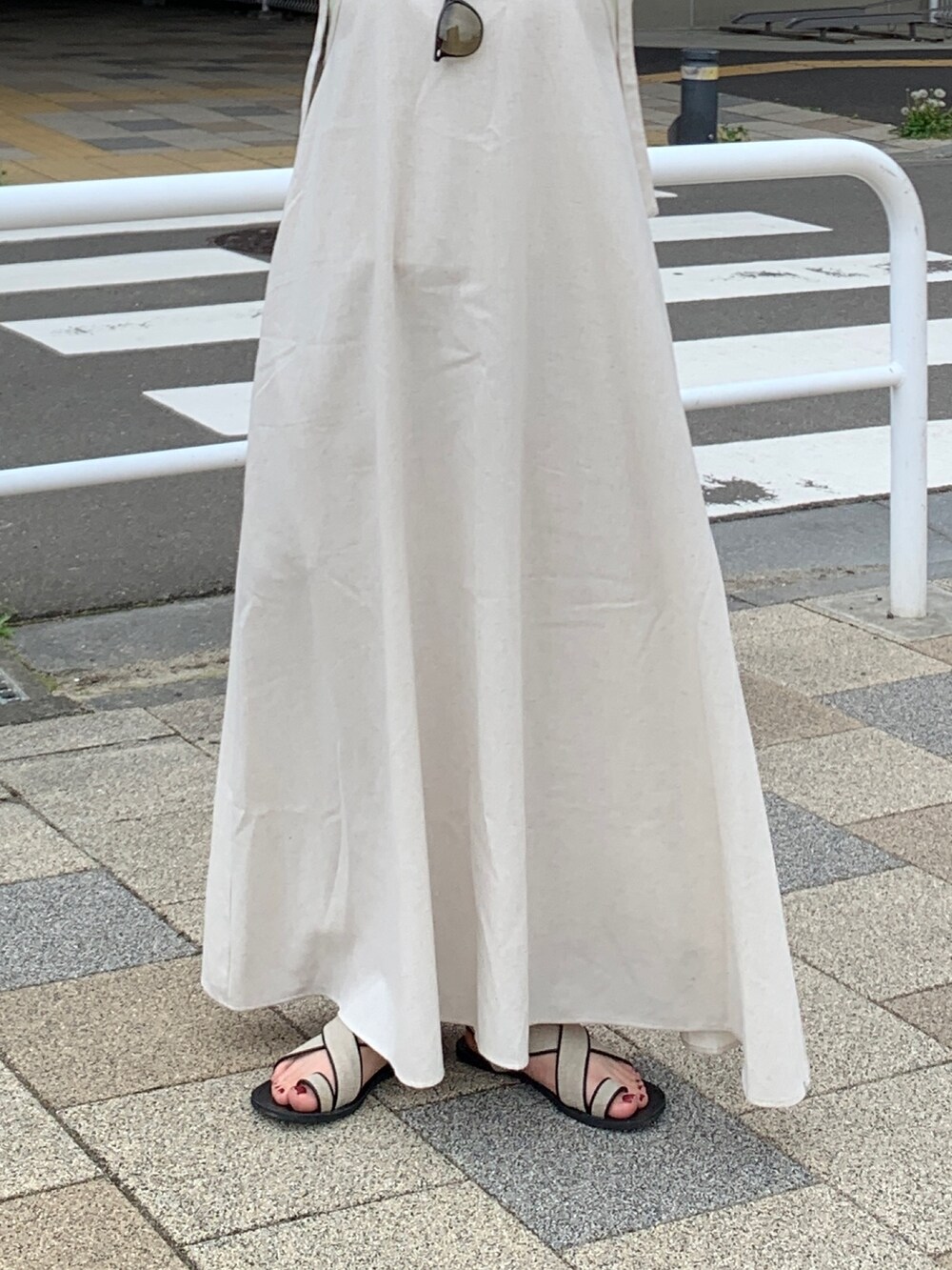 ホワイト系のワンピース、グリーン系のタンクトップを着用したレディースの春コーディネートの5枚目の写真