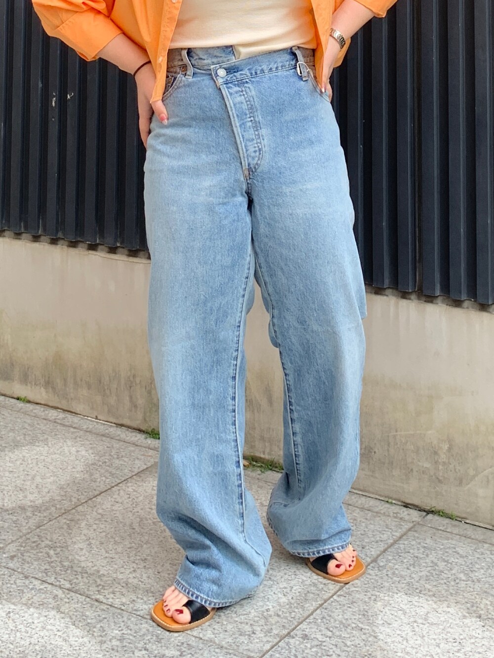 オレンジ系のシャツ/ブラウス、ホワイト系のキャミソール、ブルー系のデニムパンツを着用したレディースの春コーディネートの5枚目の写真