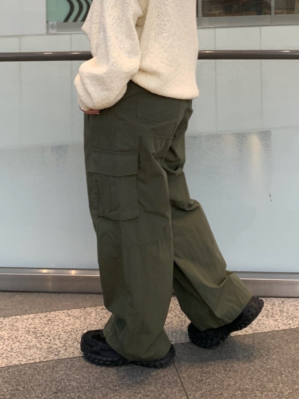 ホワイト系のニット/セーター、グリーン系のその他パンツを着用したレディースの冬コーディネートの6枚目の写真