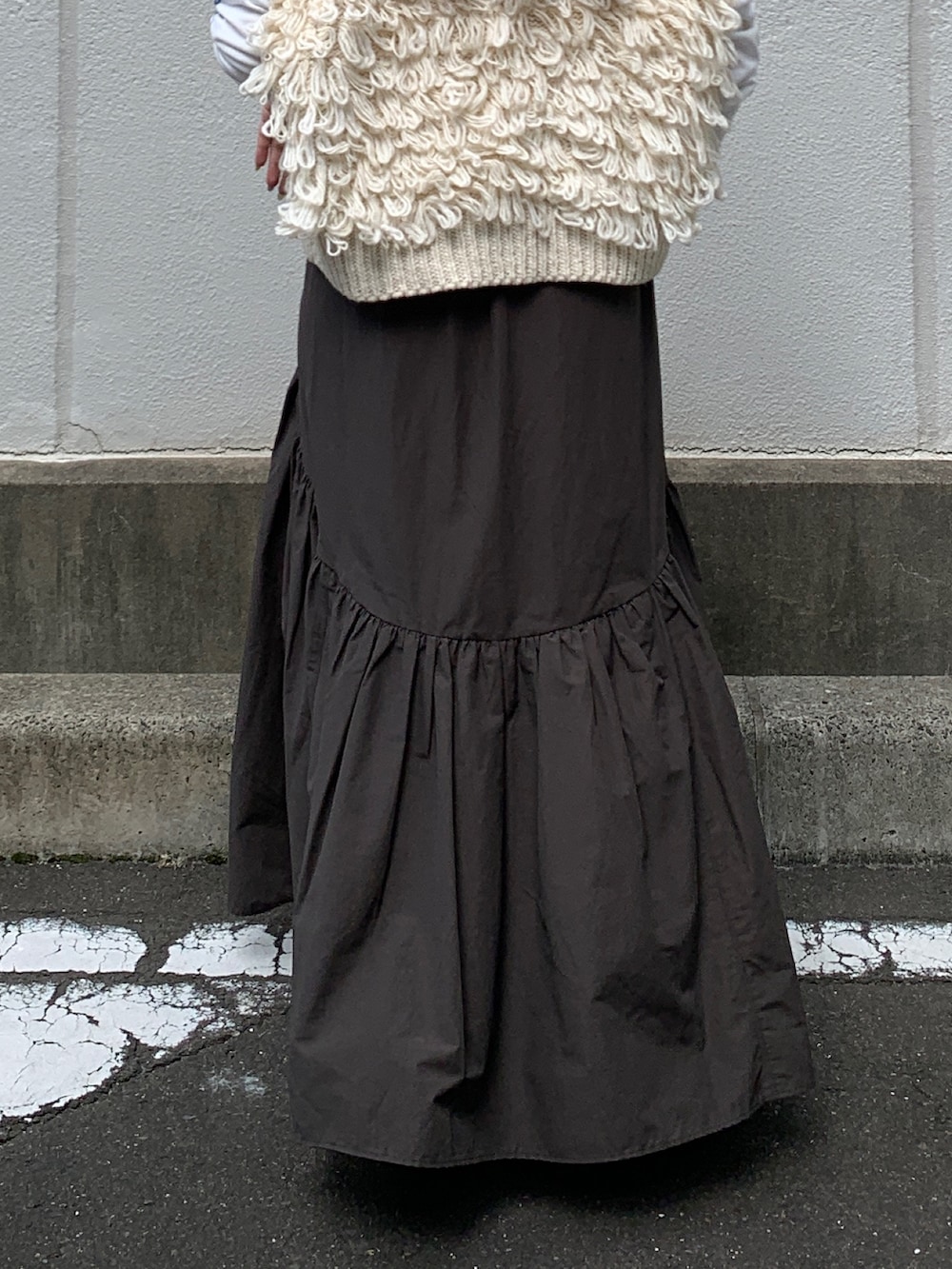 ホワイト系のTシャツ/カットソー、ホワイト系のベスト、グレー系のスカートを着用したレディースの秋コーディネートの7枚目の写真