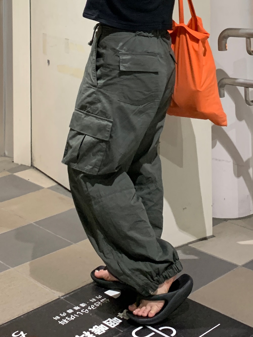 グリーン系のカーゴパンツ、ブラック系のTシャツ/カットソーを着用したレディースの夏コーディネートの6枚目の写真