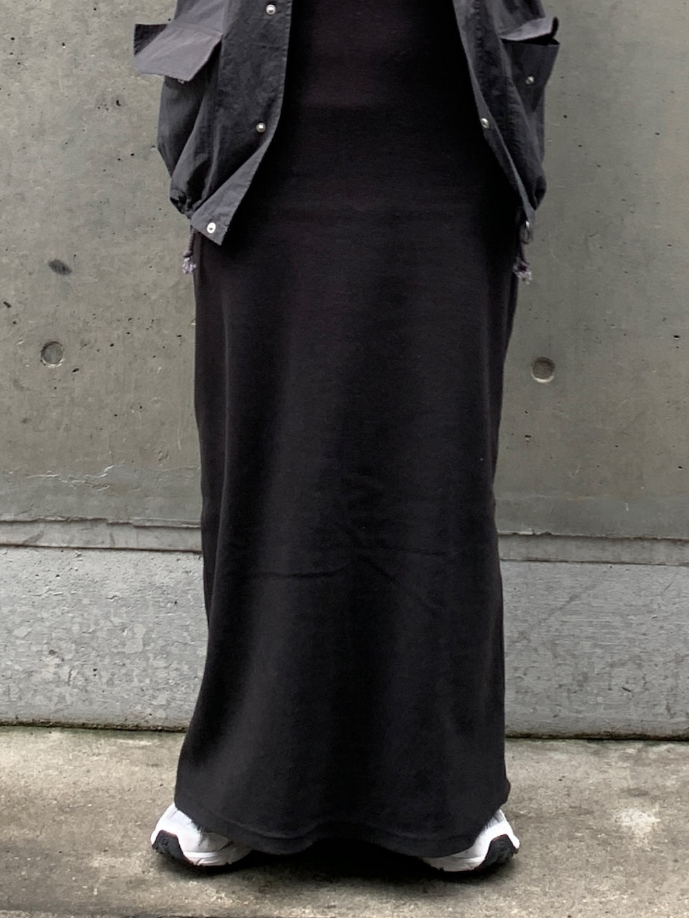 グレー系のベスト、ブラック系のワンピースを着用したレディースの春コーディネートの5枚目の写真