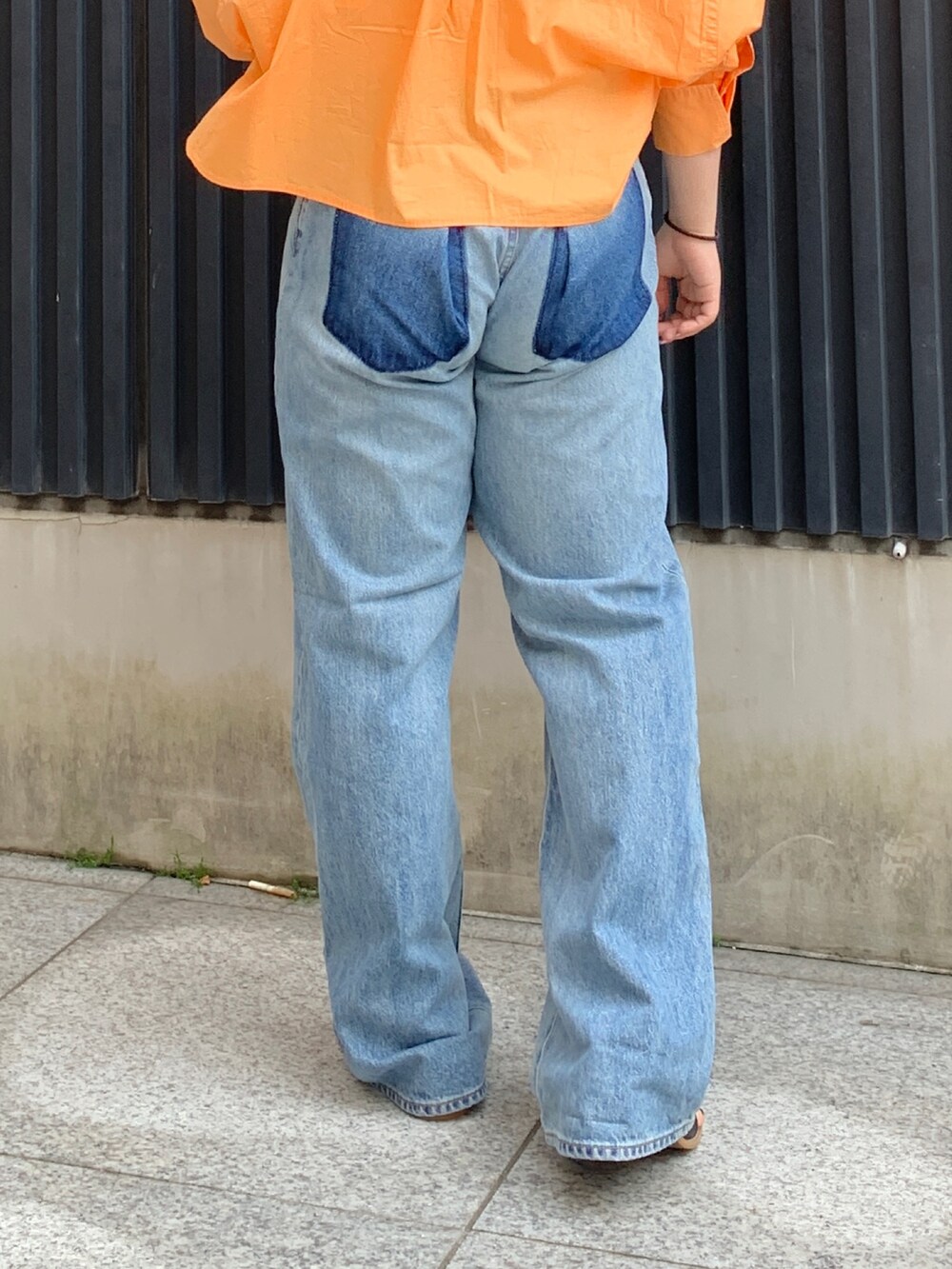 オレンジ系のシャツ/ブラウス、ホワイト系のキャミソール、ブルー系のデニムパンツを着用したレディースの春コーディネートの7枚目の写真