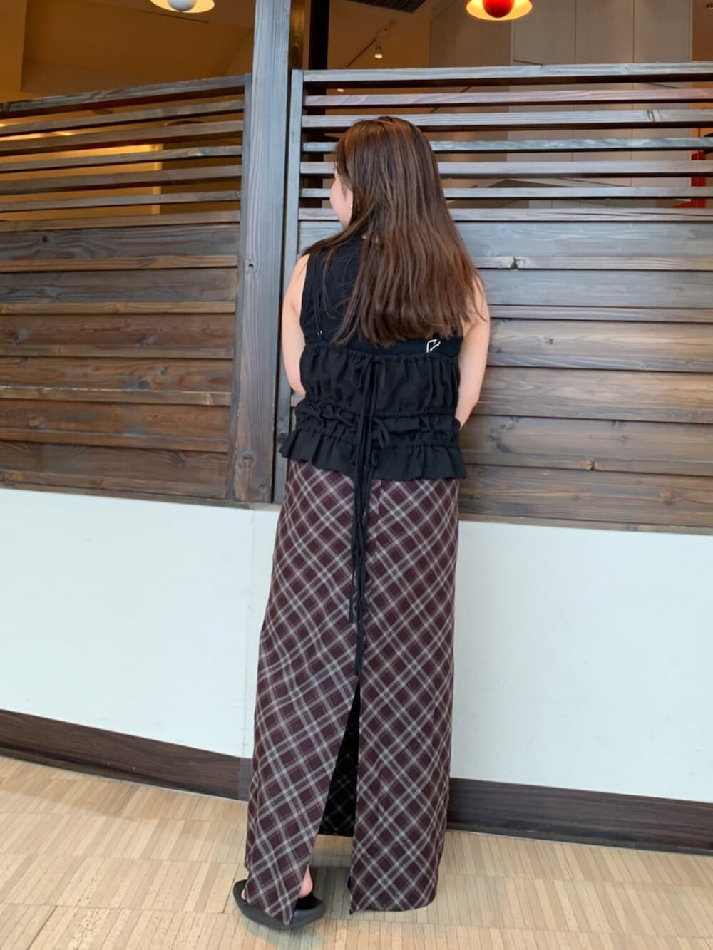 ブラック系のタンクトップ、ブラウン系のスカートを着用したレディースの夏コーディネートの3枚目の写真