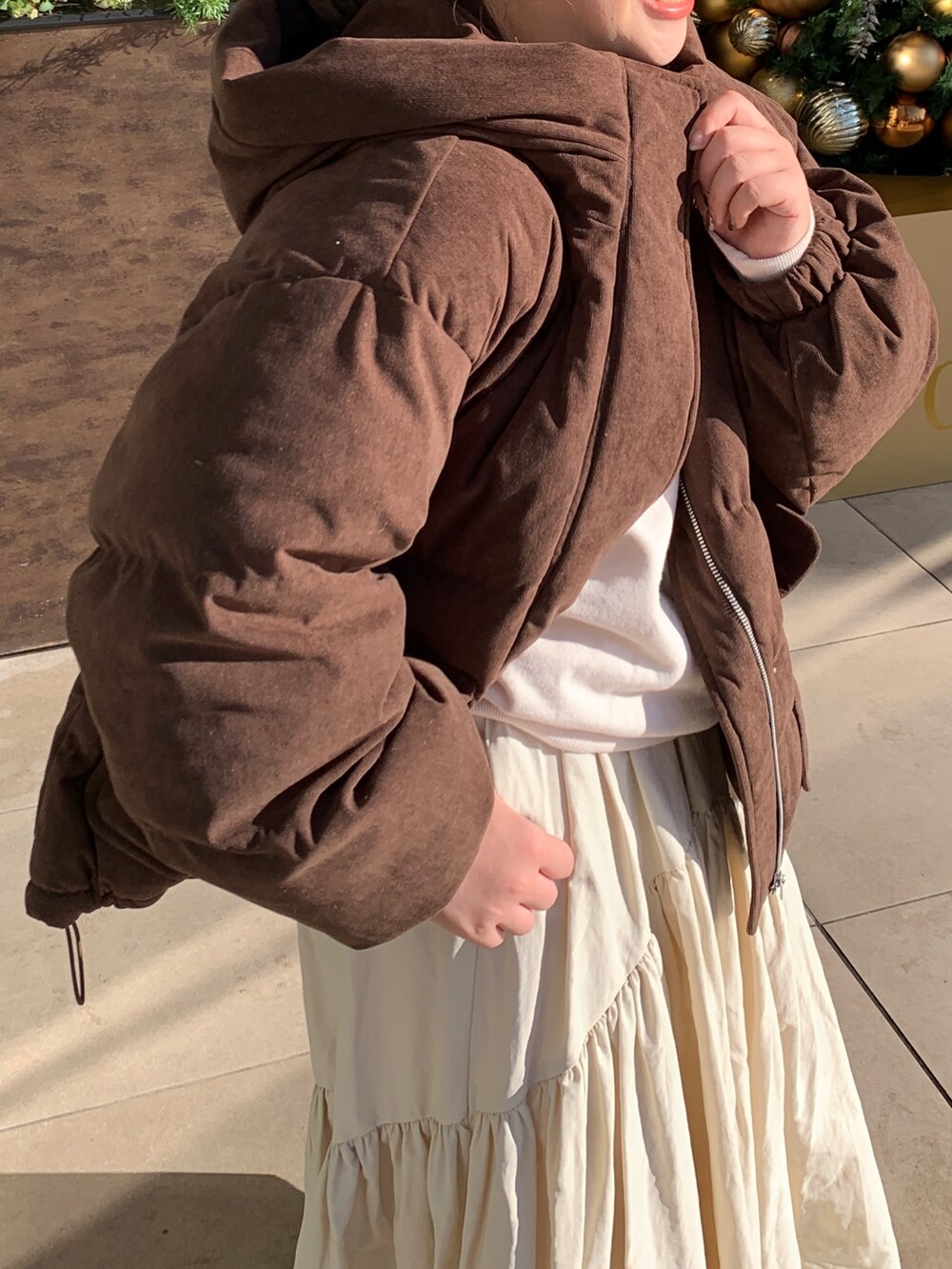 ホワイト系のスウェット、ブラウン系のブルゾン、ホワイト系のスカートを着用したレディースの冬コーディネートの7枚目の写真