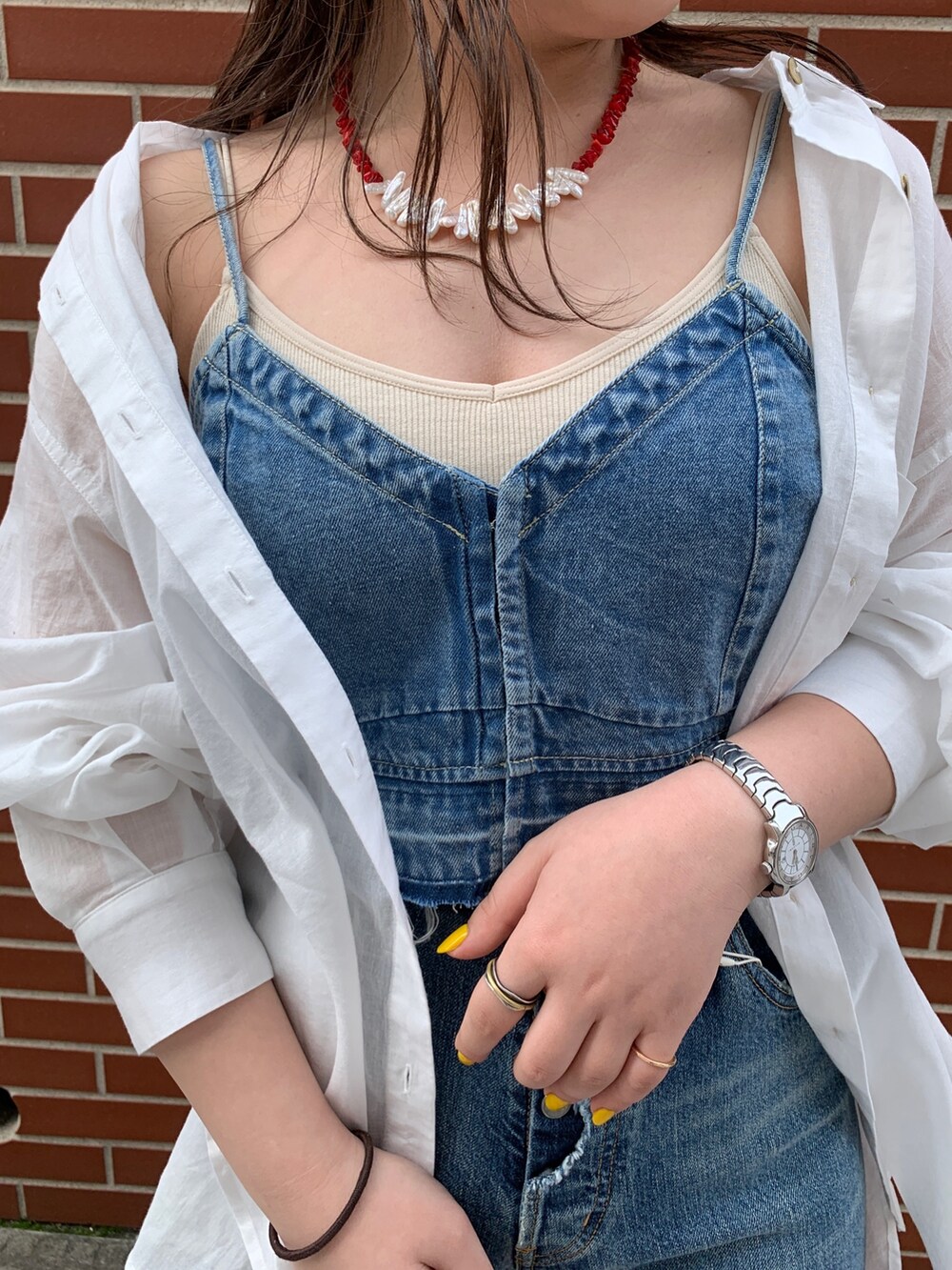 ブルー系のキャミソール、ホワイト系のシャツ/ブラウス、ブルー系のデニムパンツを着用したレディースの春コーディネートの4枚目の写真