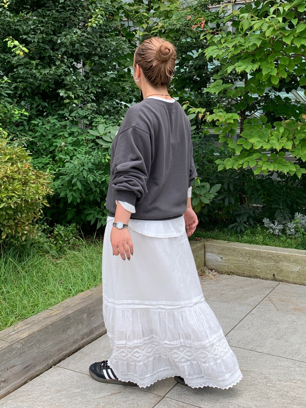 グレー系のスウェット、ホワイト系のTシャツ/カットソー、ホワイト系のスカートを着用したレディースの秋コーディネートの2枚目の写真