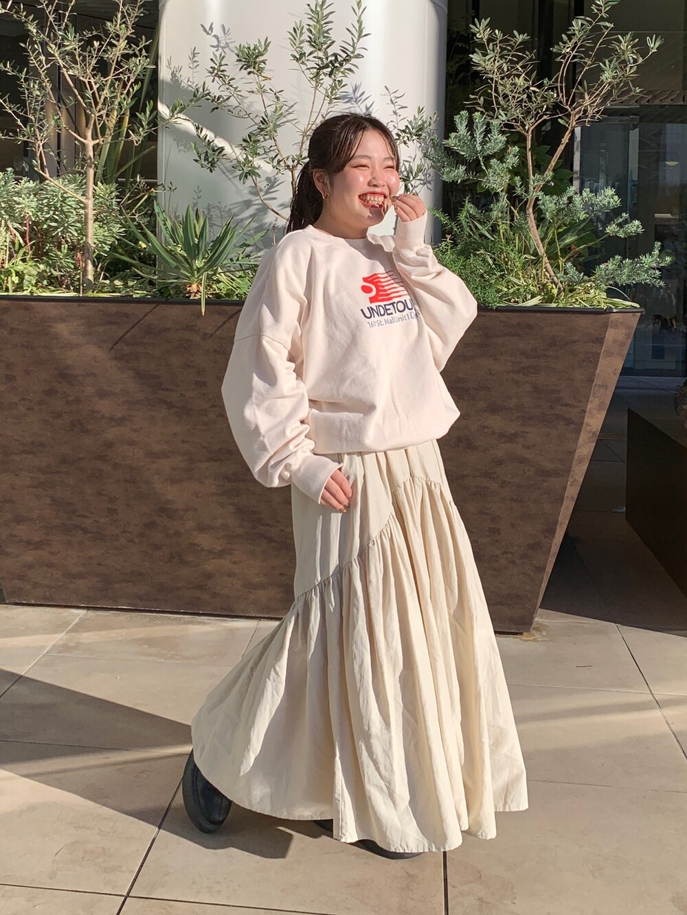 ホワイト系のスウェット、ブラウン系のブルゾン、ホワイト系のスカートを着用したレディースの冬コーディネートの5枚目の写真