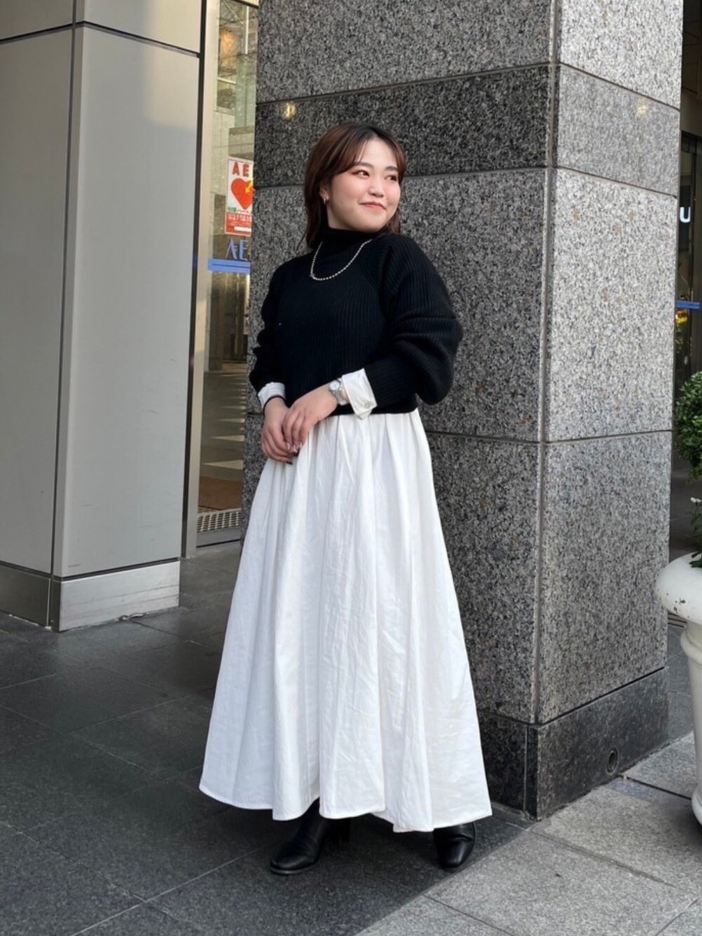 ブラウン系のムートンコート、ブラック系のワンピースを着用したレディースの秋コーディネートの5枚目の写真