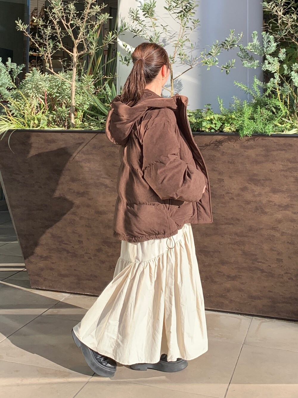 ホワイト系のスウェット、ブラウン系のブルゾン、ホワイト系のスカートを着用したレディースの冬コーディネートの2枚目の写真