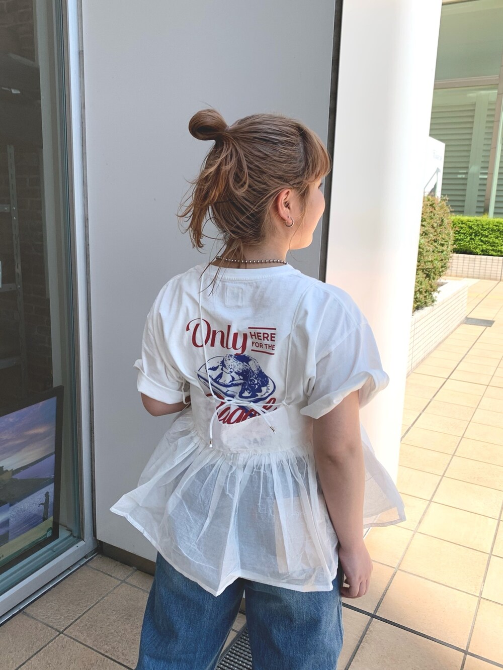 ホワイト系のシャツ/ブラウス、ホワイト系のTシャツ/カットソー、ブルー系のデニムパンツを着用したレディースの春コーディネートの3枚目の写真