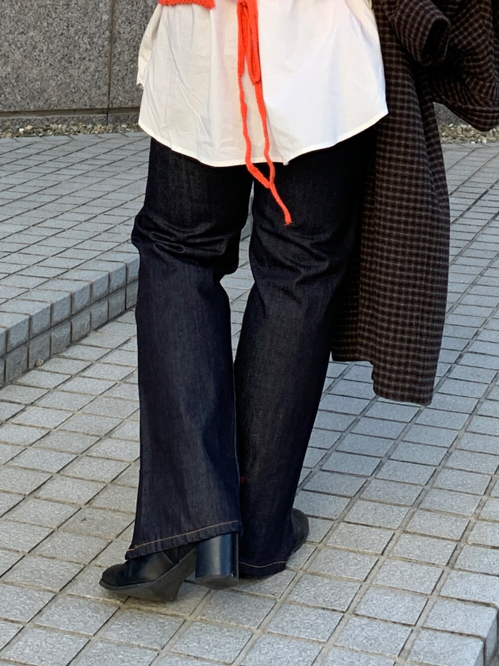 オレンジ系のニット/セーター、その他のチェスターコート、ブルー系のデニムパンツを着用したレディースの秋コーディネートの10枚目の写真