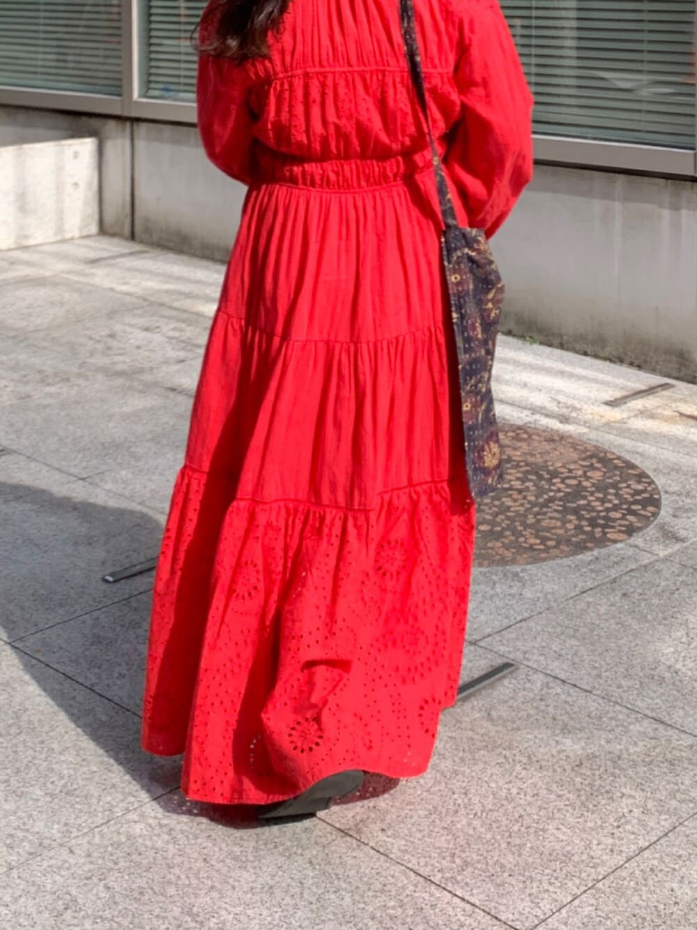 レッド系のワンピース、ブラック系のショルダーバッグ、レッド系のネックレスを着用したレディースの冬コーディネートの7枚目の写真