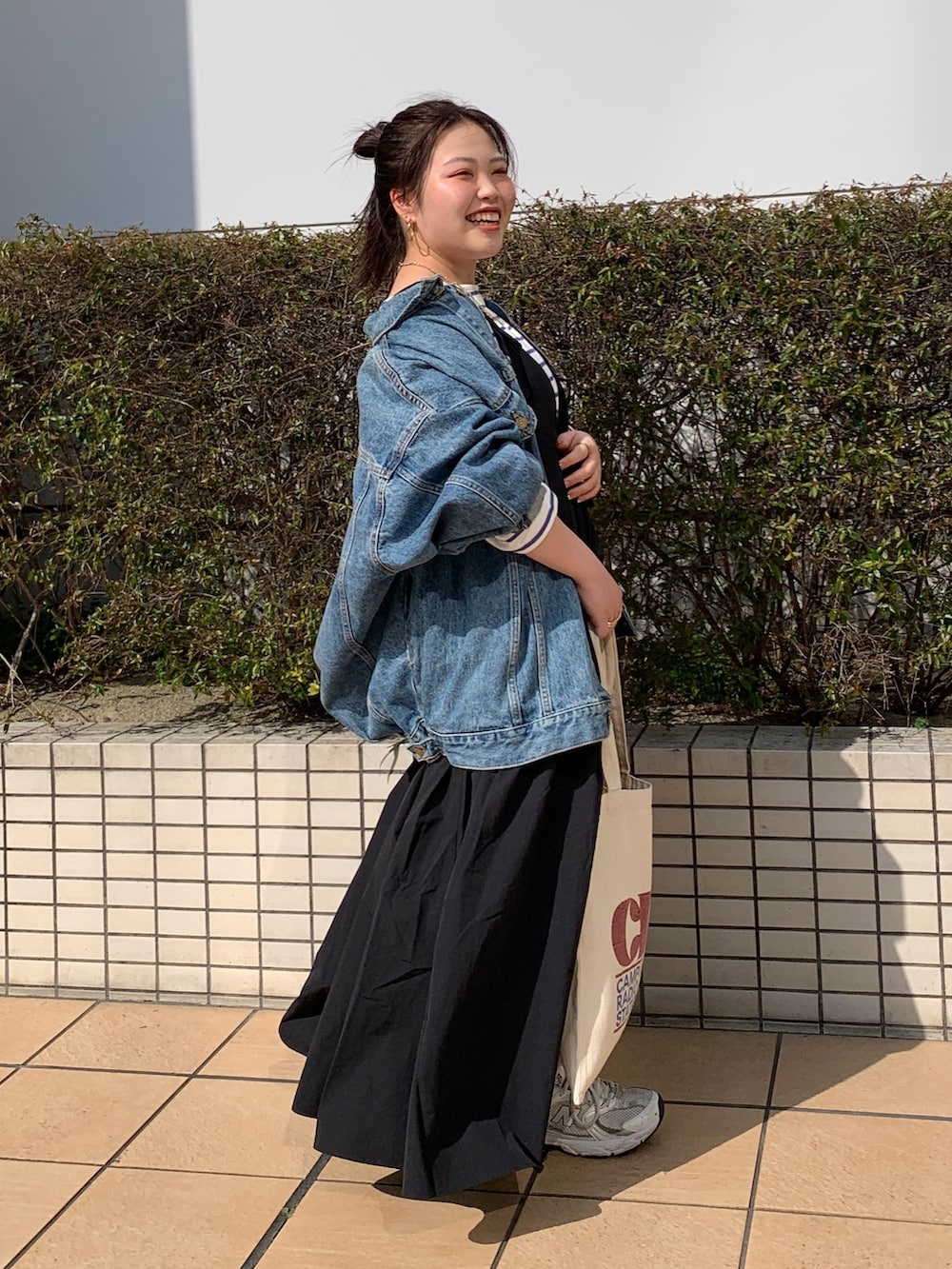 ホワイト系のTシャツ/カットソー、ブルー系のデニムジャケット、ブラック系のワンピースを着用したレディースの春コーディネートの2枚目の写真