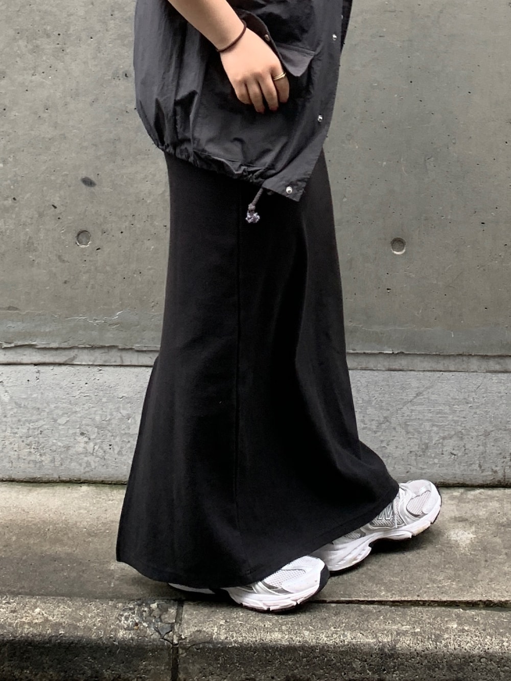 グレー系のベスト、ブラック系のワンピースを着用したレディースの春コーディネートの6枚目の写真