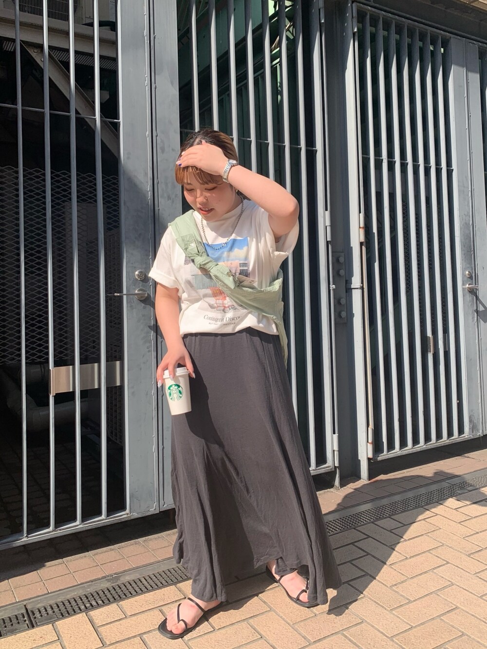 ホワイト系のTシャツ/カットソー、グリーン系のシャツ/ブラウス、グレー系のスカートを着用したレディースの春コーディネートの2枚目の写真