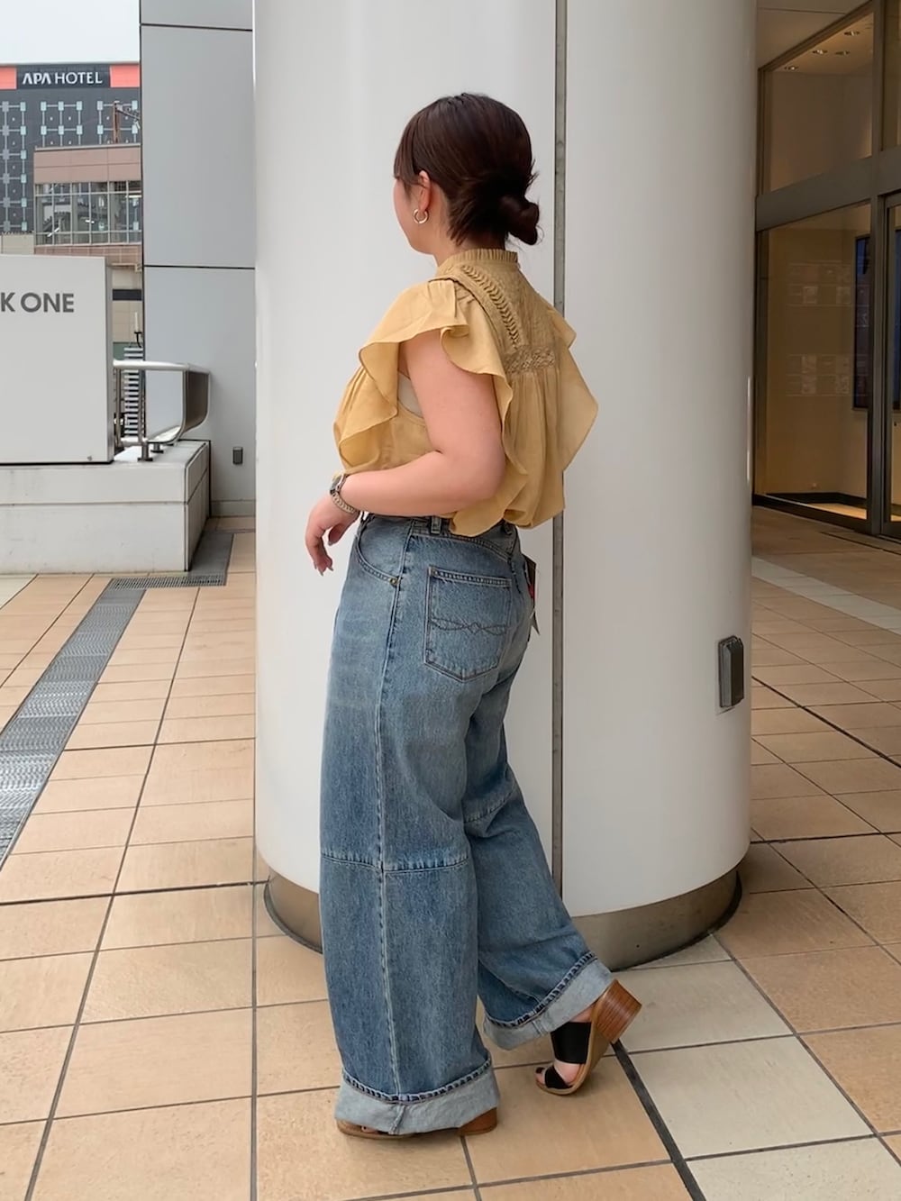 イエロー系のシャツ/ブラウス、ブルー系のデニムパンツを着用したレディースの夏コーディネートの2枚目の写真