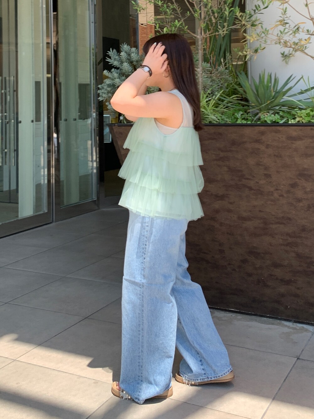 グリーン系のシャツ/ブラウス、ブルー系のデニムパンツを着用したレディースの夏コーディネートの2枚目の写真