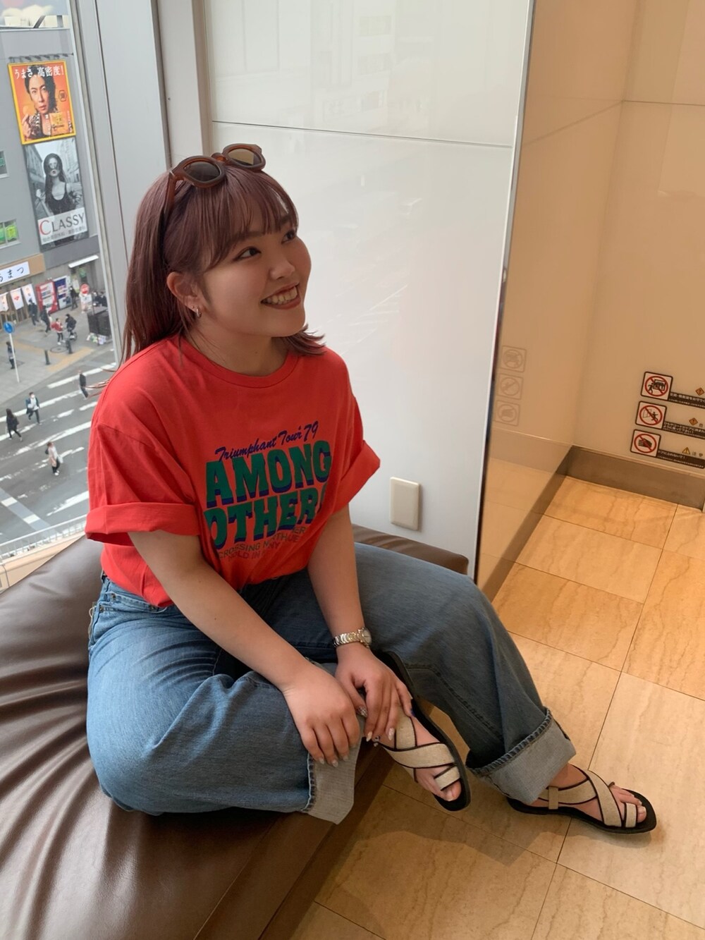 オレンジ系のTシャツ/カットソー、ブルー系のデニムパンツ、その他のサンダルを着用したレディースの春コーディネートの4枚目の写真