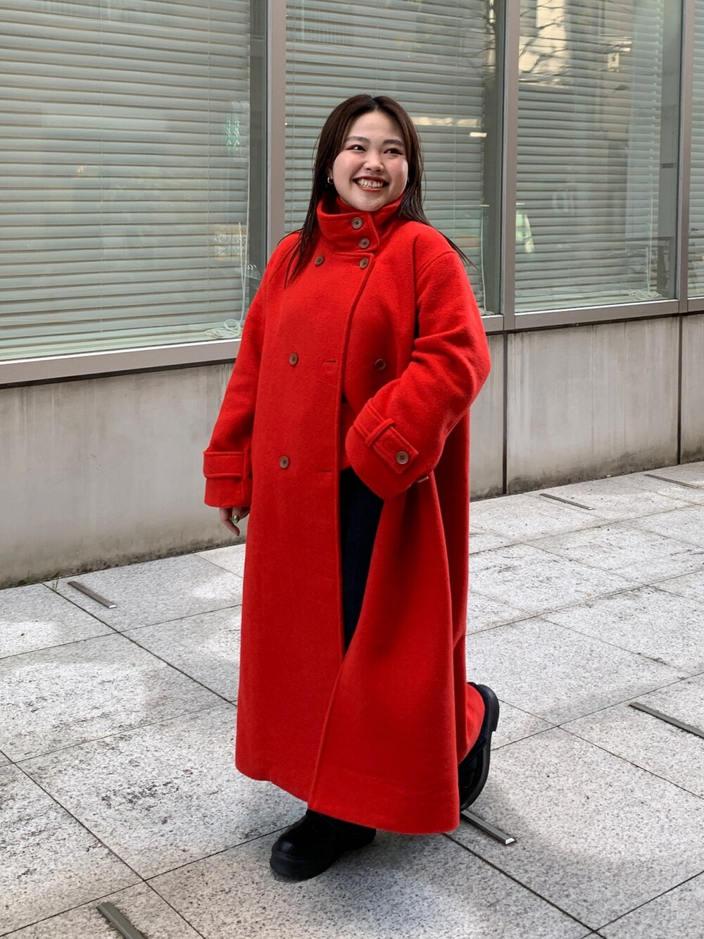 レッド系のその他アウター、ブルー系のデニムパンツを着用したレディースの冬コーディネートの2枚目の写真