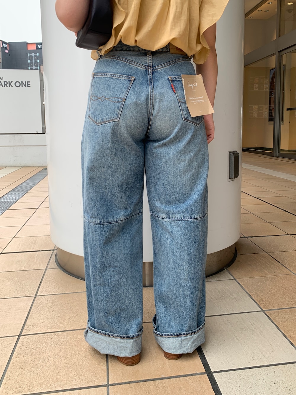 イエロー系のシャツ/ブラウス、ブルー系のデニムパンツを着用したレディースの夏コーディネートの7枚目の写真