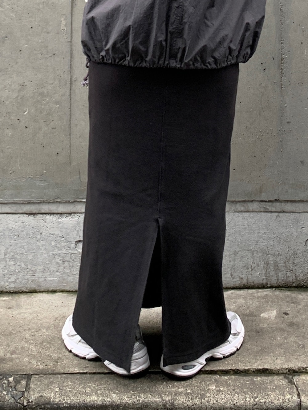 グレー系のベスト、ブラック系のワンピースを着用したレディースの春コーディネートの7枚目の写真