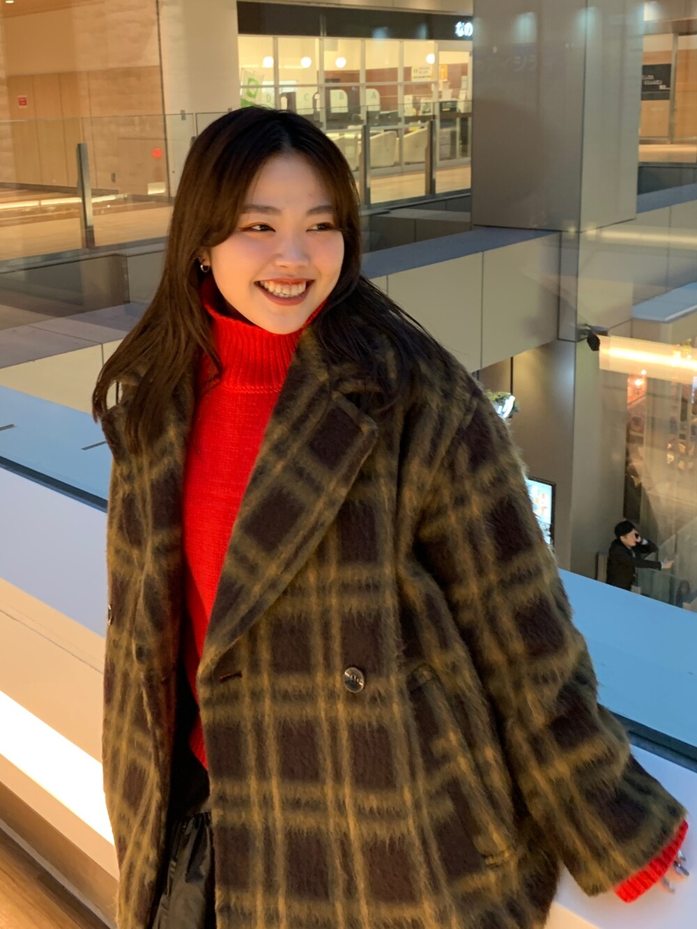 レッド系のニット/セーター、その他のピーコート、ブラック系のスカートを着用したレディースの冬コーディネートの4枚目の写真