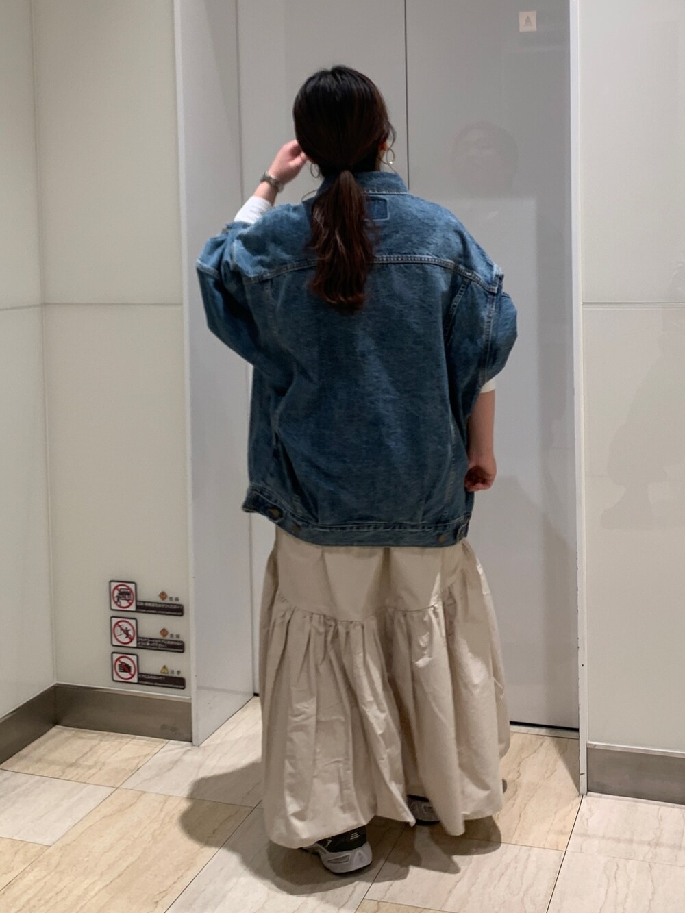 ブルー系のデニムジャケット、ホワイト系のTシャツ/カットソー、ホワイト系のスカートを着用したレディースの冬コーディネートの3枚目の写真