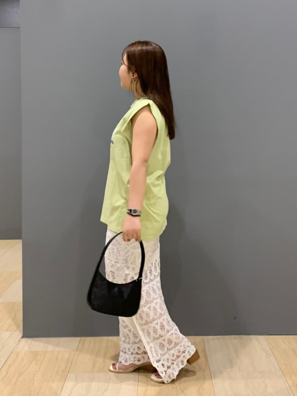 グリーン系のタンクトップ、ホワイト系のスカートを着用したレディースの夏コーディネートの2枚目の写真