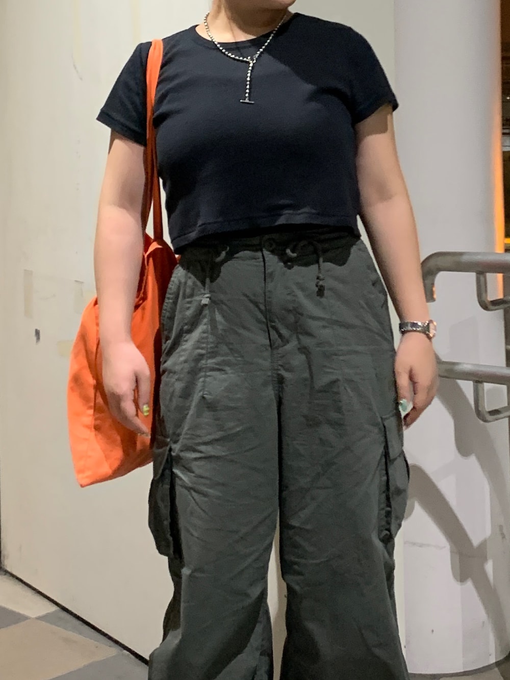 グリーン系のカーゴパンツ、ブラック系のTシャツ/カットソーを着用したレディースの夏コーディネートの4枚目の写真