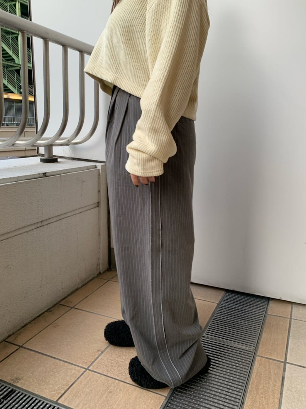 ブラック系のスリッポン、イエロー系のTシャツ/カットソー、グレー系のその他パンツを着用したレディースの冬コーディネートの6枚目の写真