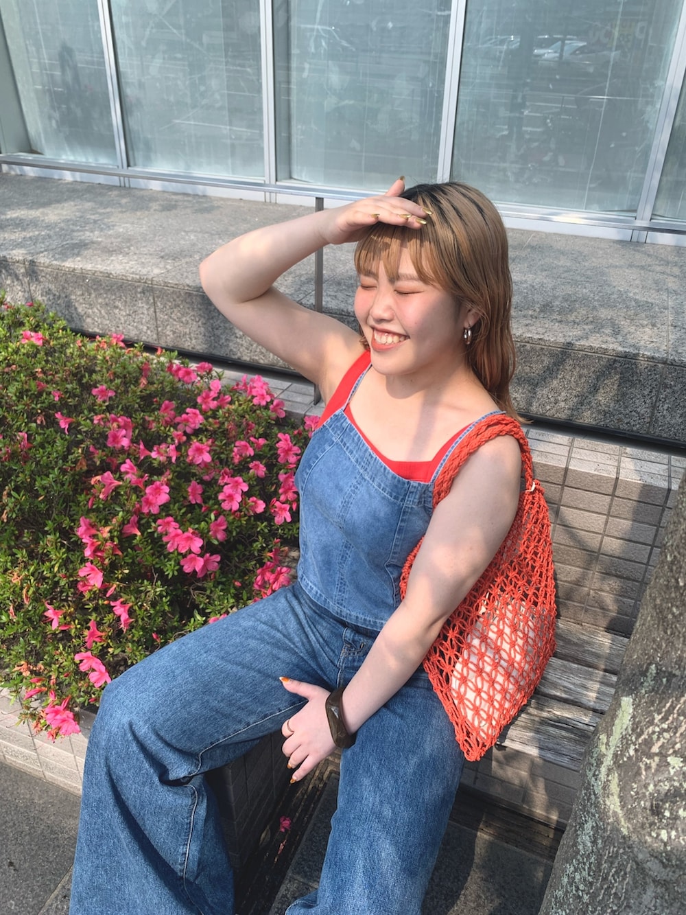 オレンジ系のタンクトップ、オレンジ系のハンドバッグを着用したレディースの夏コーディネートの4枚目の写真