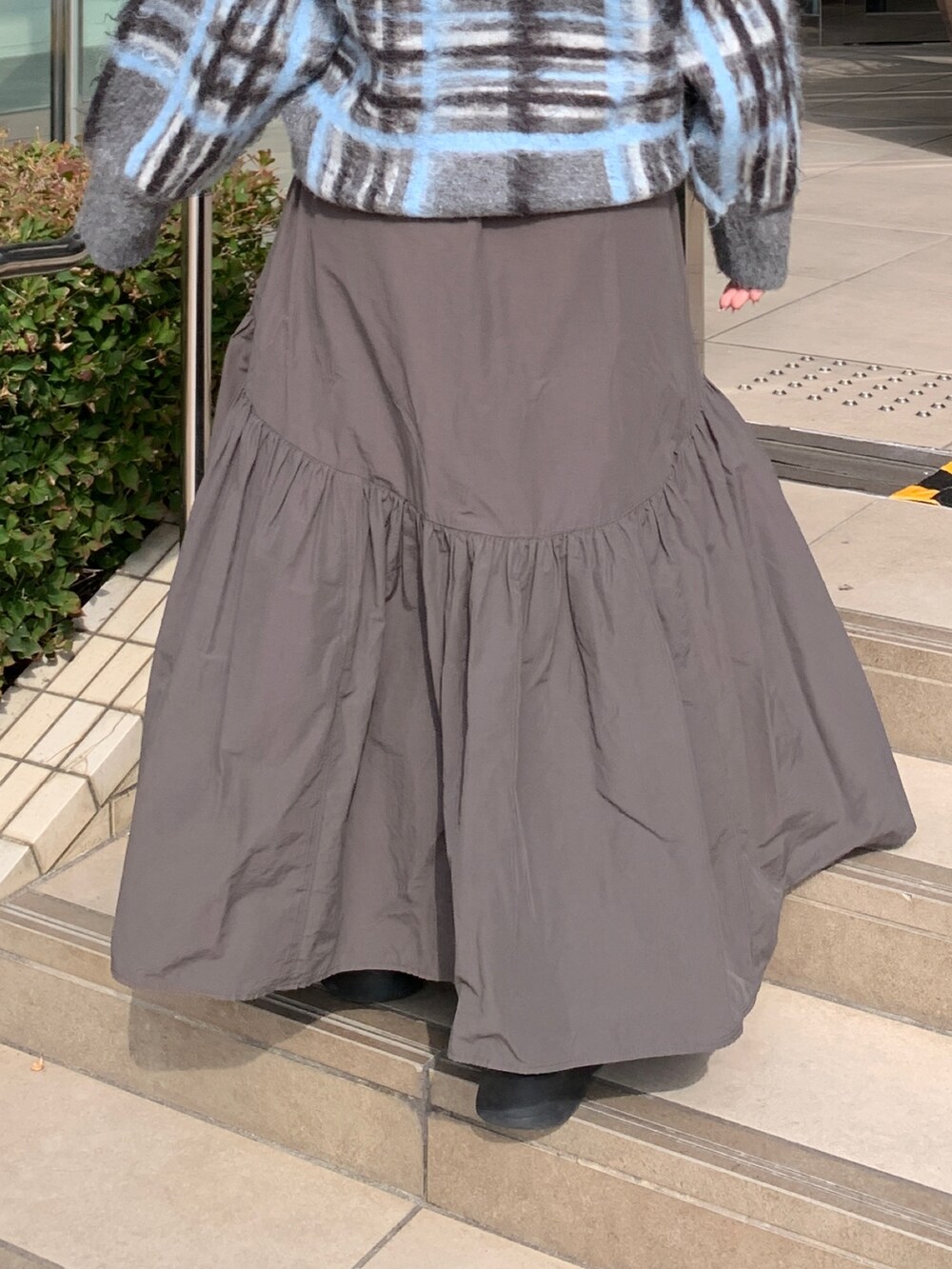 グレー系のニット/セーター、グレー系のスカートを着用したレディースの秋コーディネートの7枚目の写真