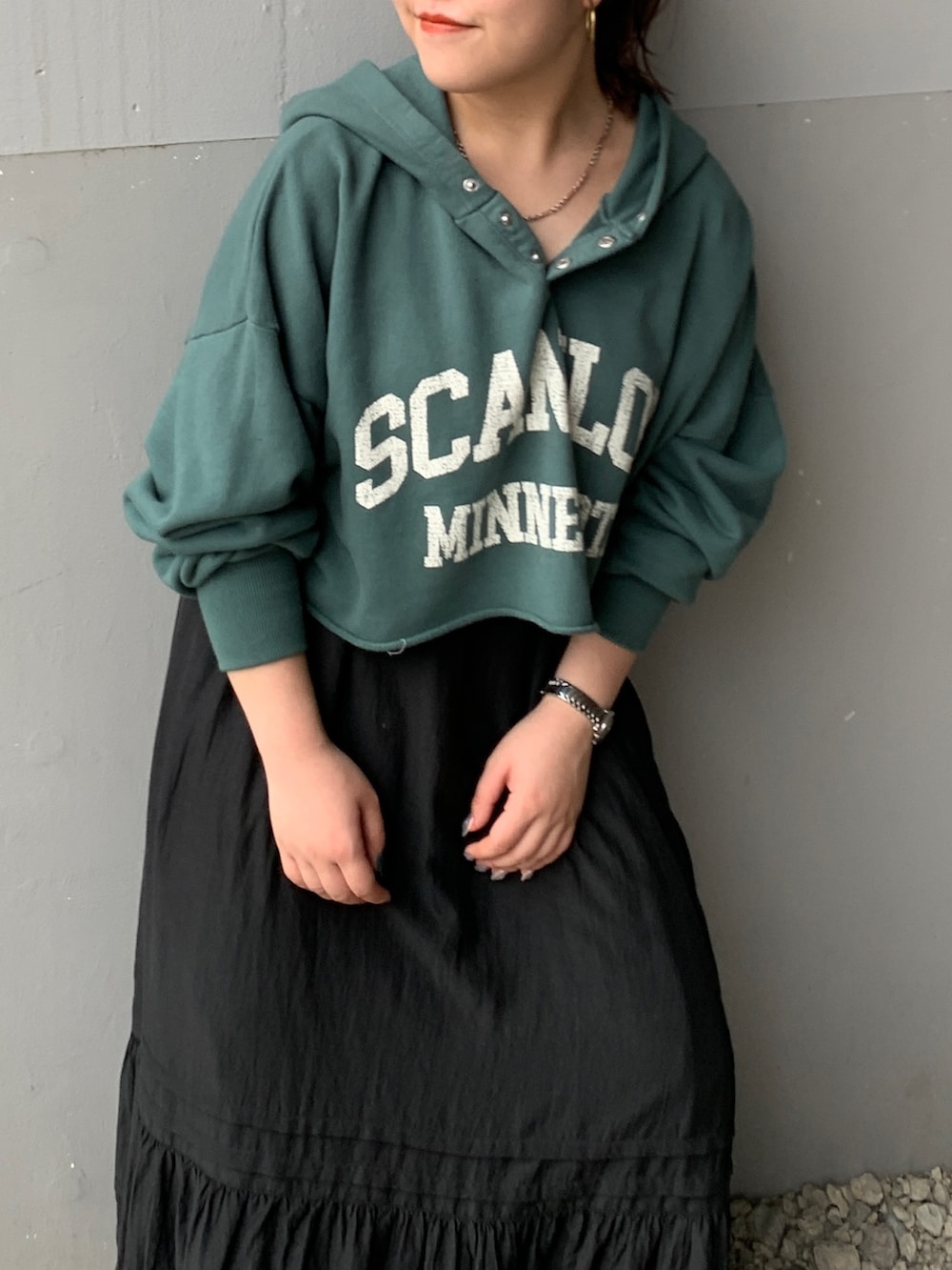 グリーン系のパーカー、ブラック系のスカートを着用したレディースの夏コーディネートの4枚目の写真