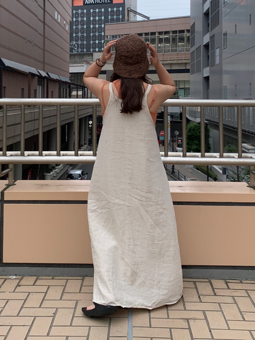 ホワイト系のワンピース、ブラウン系のニットキャップ/ビーニーを着用したレディースの夏コーディネートの3枚目の写真