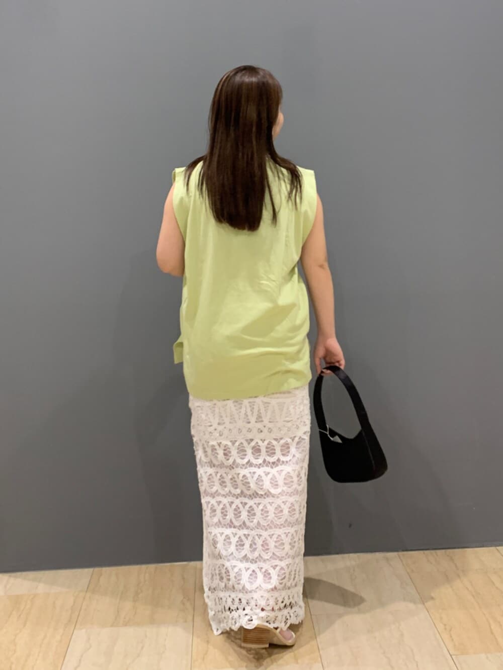 グリーン系のタンクトップ、ホワイト系のスカートを着用したレディースの夏コーディネートの3枚目の写真