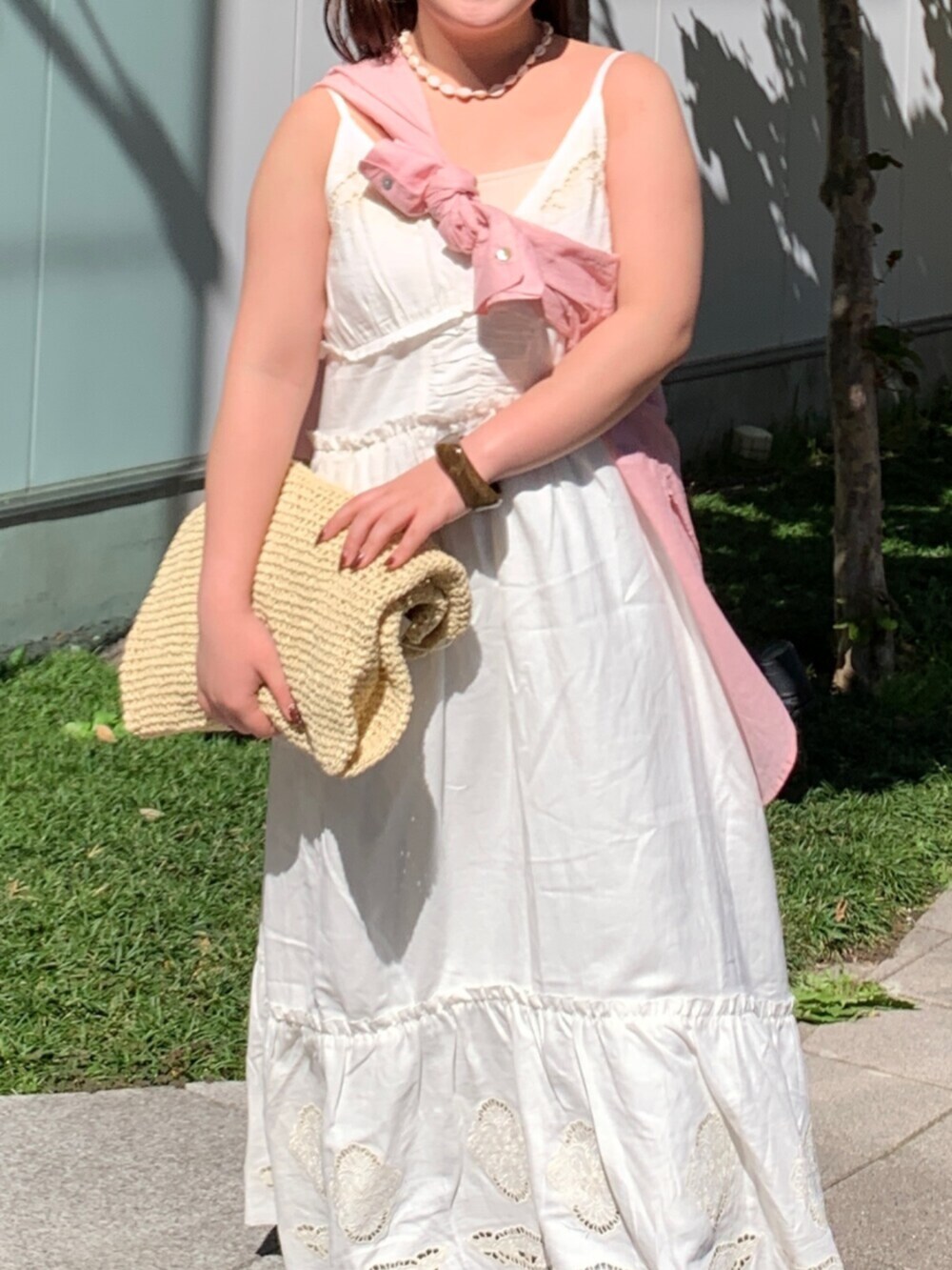 ピンク系のシャツ/ブラウス、ホワイト系のワンピース、ベージュ系のショルダーバッグを着用したレディースの春コーディネートの4枚目の写真