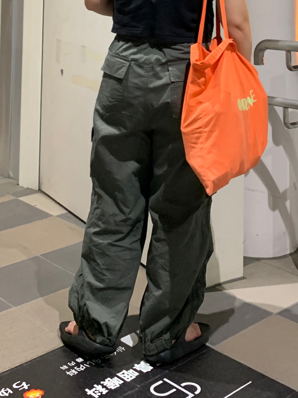 グリーン系のカーゴパンツ、ブラック系のTシャツ/カットソーを着用したレディースの夏コーディネートの7枚目の写真