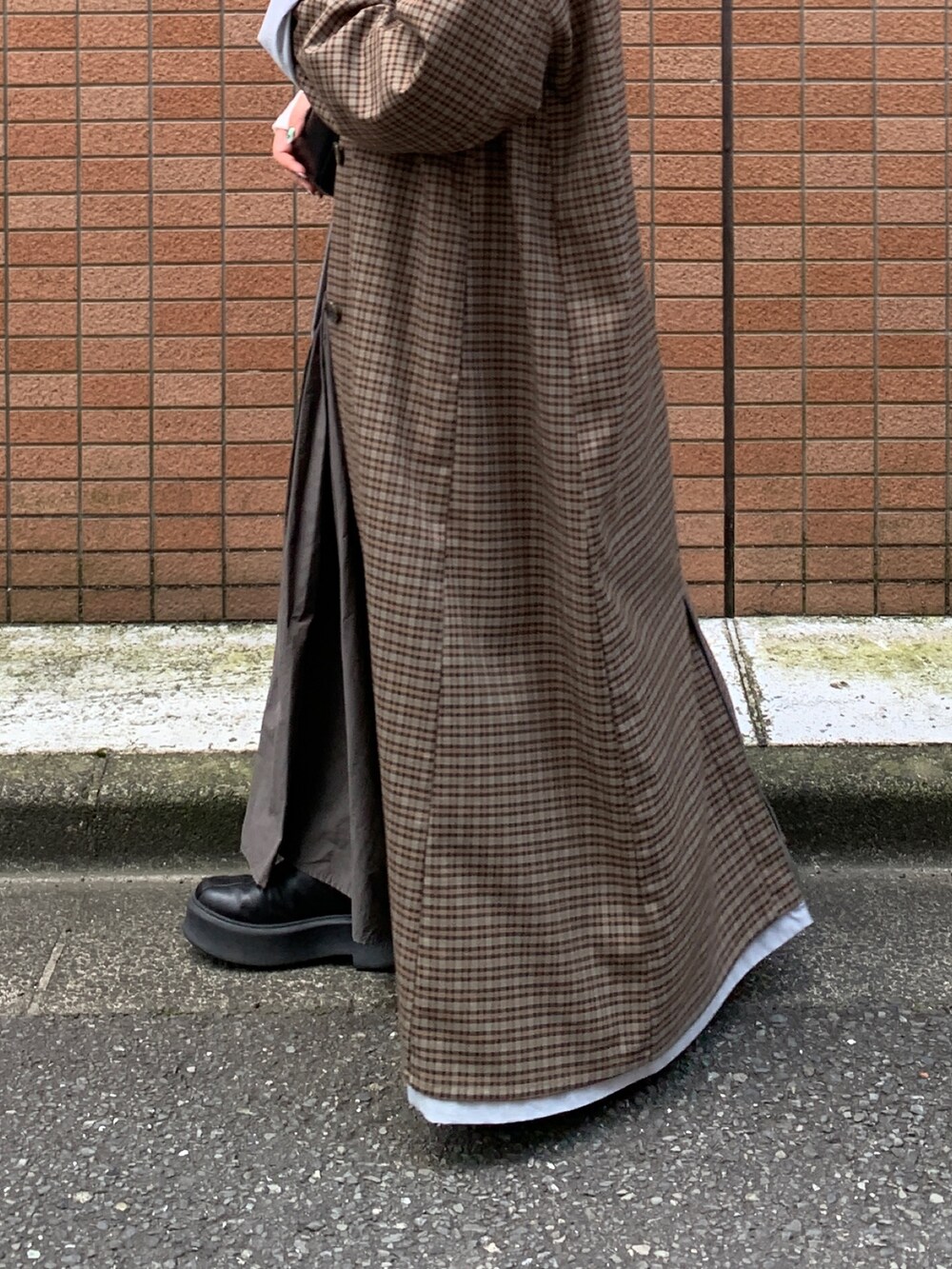 グレー系のスカート、ブルー系のステンカラーコートを着用したレディースの秋コーディネートの6枚目の写真