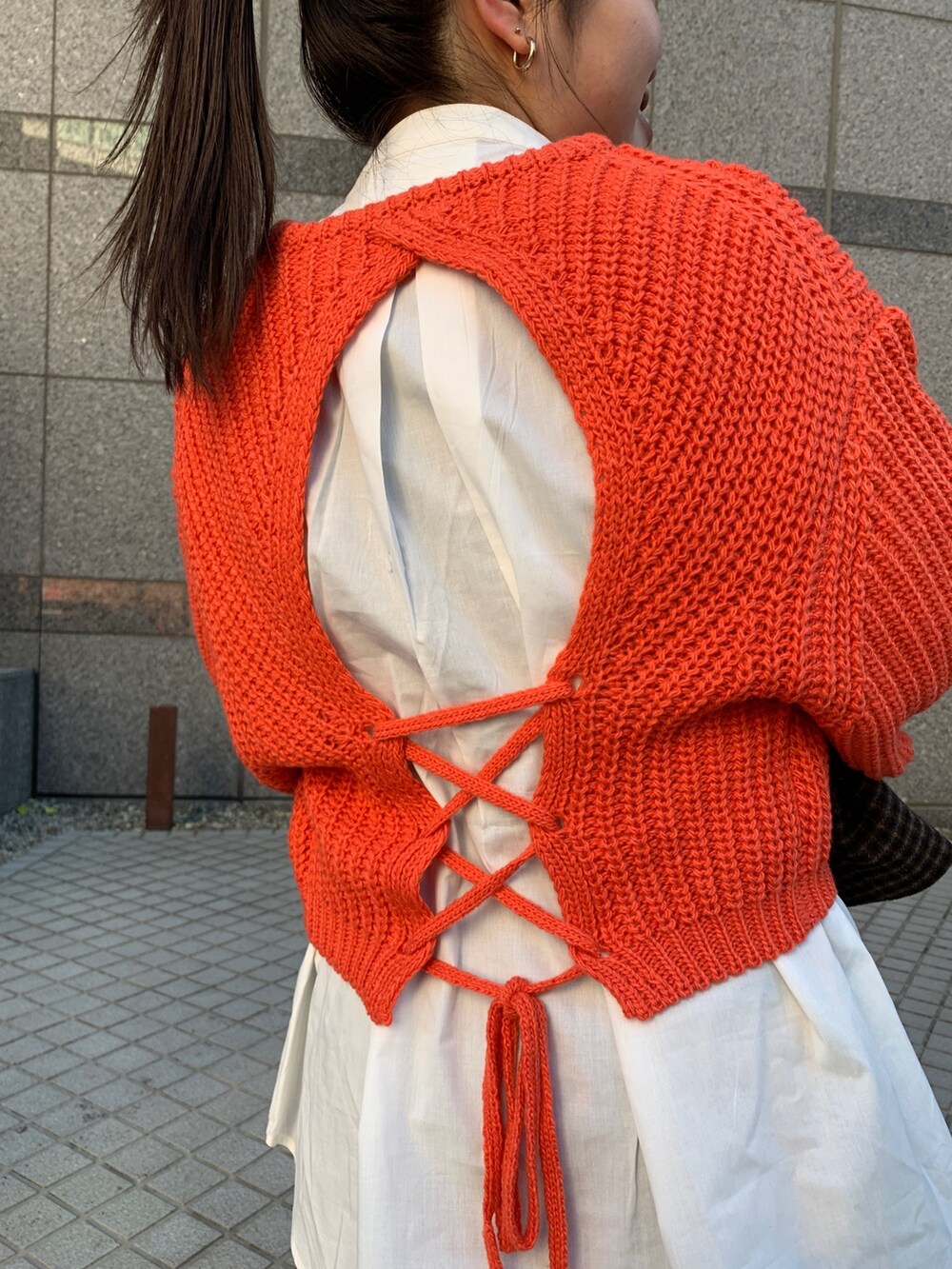 オレンジ系のニット/セーター、その他のチェスターコート、ブルー系のデニムパンツを着用したレディースの秋コーディネートの7枚目の写真